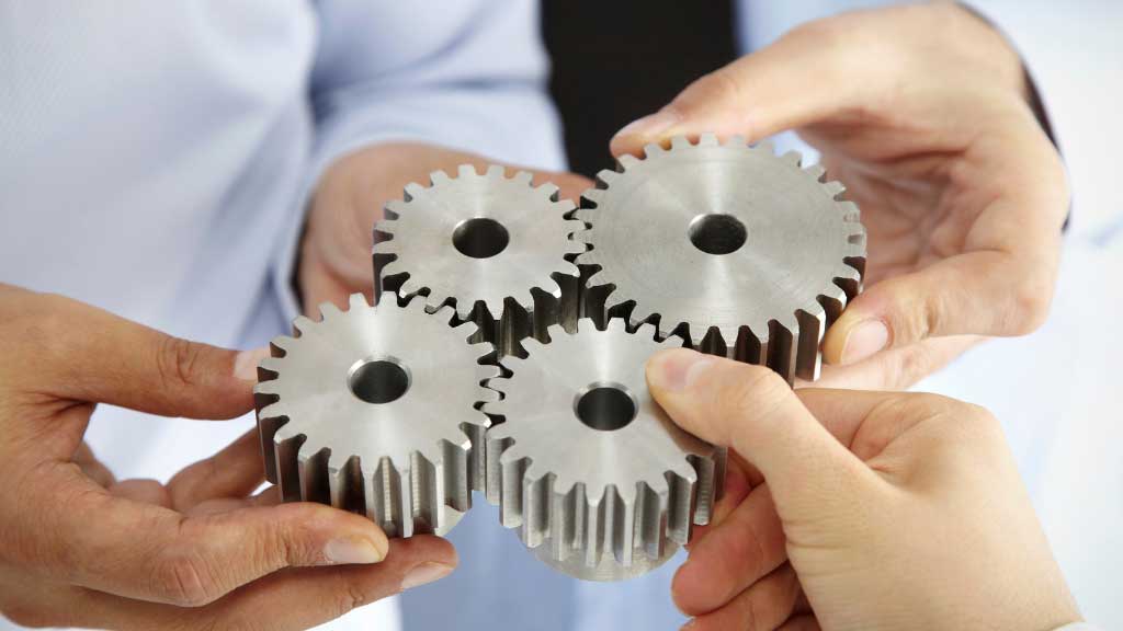 A photo of business people holding cogs